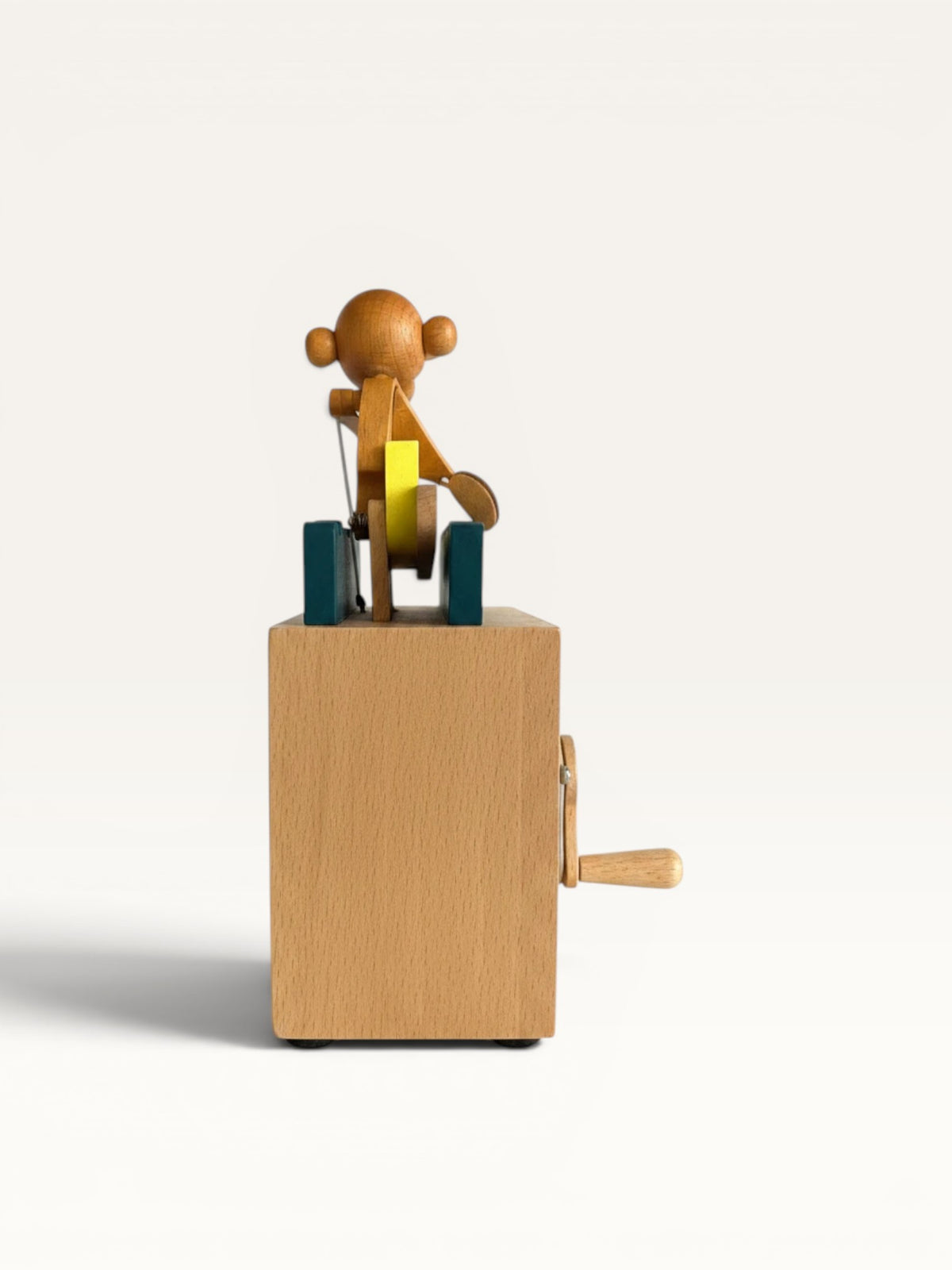Juguete mecánico de madera Retrópica Tienda con figura de mono remando en canoa amarilla sobre base de madera natural.