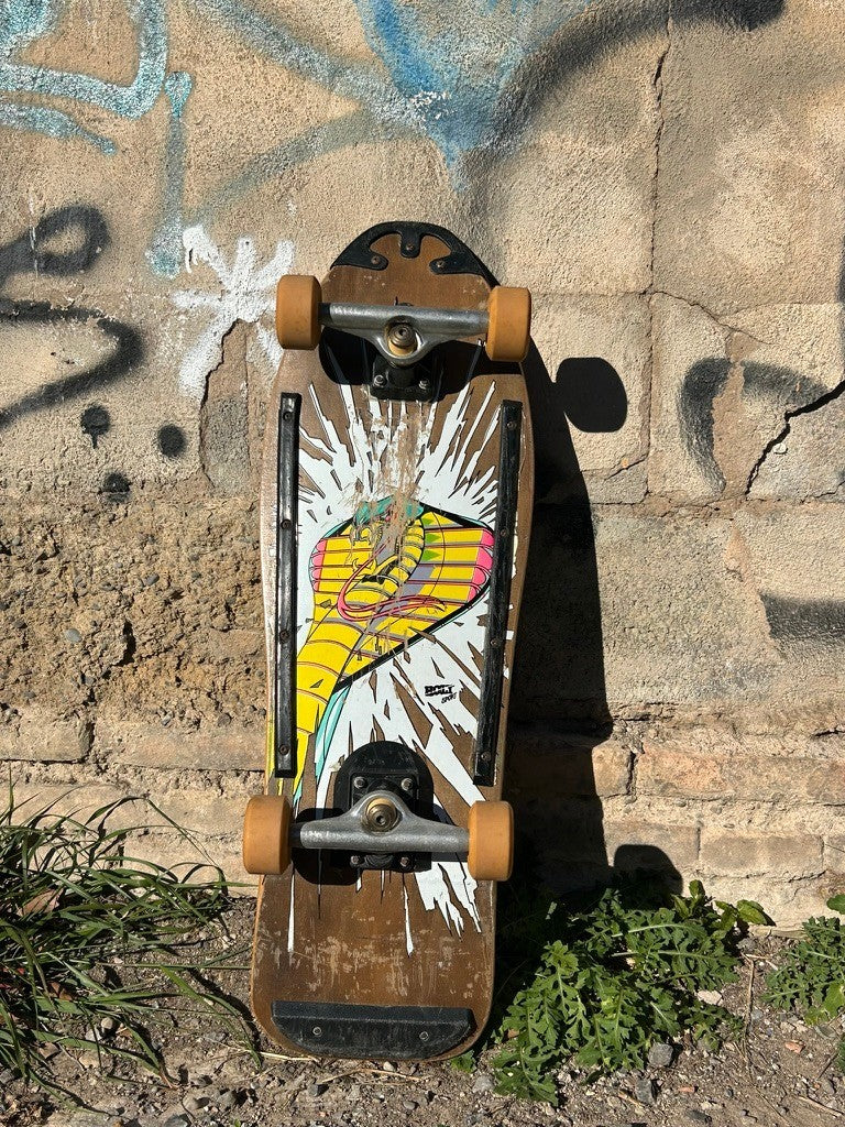 Skateboard vintage Retrópica Tienda IMSPORT de madera con diseño de cobra y colores fluo, estilo años 80.